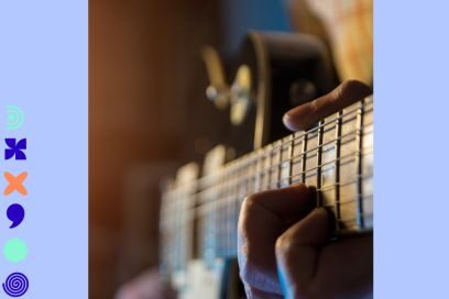 photo floûtée en plan rapproché d'une main jouant d'une guitare classique nimbée d'une lumière de scène tamisée - Agrandir l'image, fenêtre modale