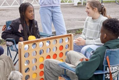 photo de trois jeunes assis en train de discuter autour d'un jeu en bois - Agrandir l'image 2 sur 3, fenêtre modale