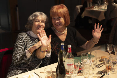 Photo de deux femmes âgées à table qui sourient à l'objectif, l'une tient les mains en l'air - Agrandir l'image 9 sur 20, fenêtre modale