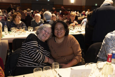 photo de deux femmes âgées assises à table, l'une à la tête sur l'épaule de l'autre et elles sourient à l'objectif - Agrandir l'image 17 sur 20, fenêtre modale