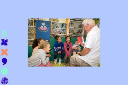 photo d'un jeune homme soixantenaire en chemise polo blanche et pantalon beige en coton, en train de faire la lecture accroupi de dos à un petit groupe d'enfants assis dans une bibliothèque et souriant encercle devant lui, en tenues de sport colorées - Agrandir l'image, fenêtre modale