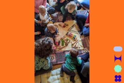 Photo prise en plongée de jeunes enfants installés sur des coussins autour d'un tapis de jeu dans une ambiance conviviale et détendue. - Agrandir l'image, fenêtre modale