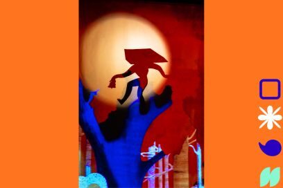 photo du spectacle de théâtre d'ombres et papier découpé et coloré du spectacle de La Soupe Cie, qui inspire cet atelier figurant un personnage avec une cape en ombres chinoises qui apparaît dans le halo d'une lune pleine, juché sur une branche d'arbre bleu nuit. - Agrandir l'image, fenêtre modale