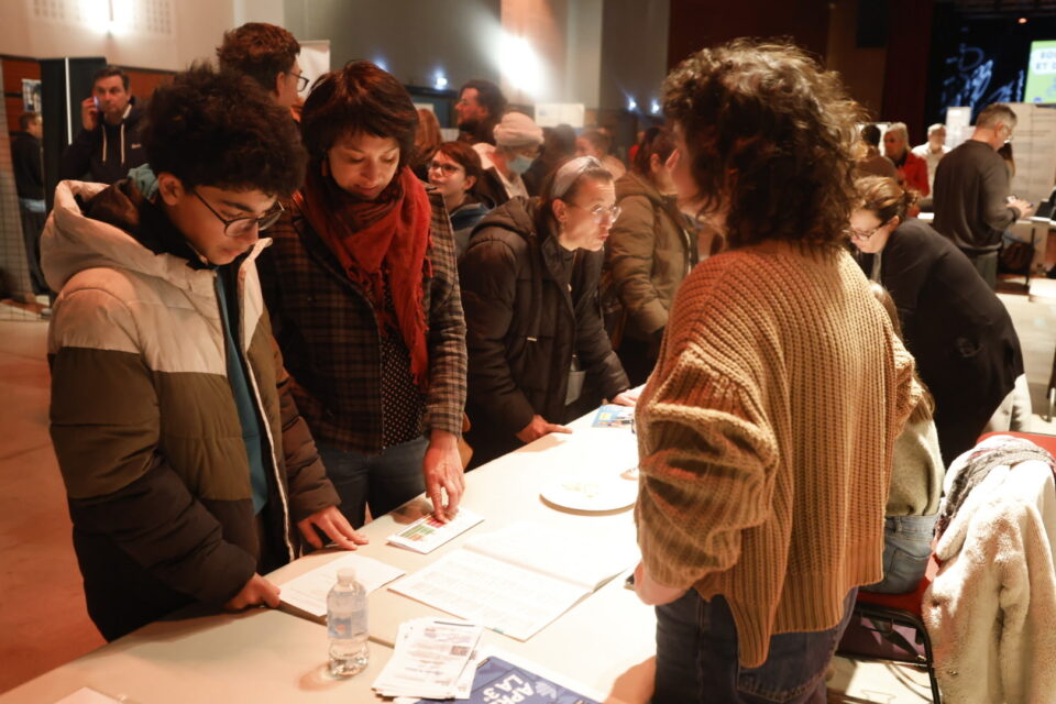 photo d'un jeune garçon et d'une femme qui échangent avec une femme derrière un stand