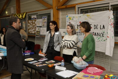 photo d'un homme qui échange avec trois femmes debout derrière un stand - Agrandir l'image 6 sur 22, fenêtre modale