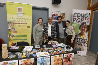 photo de quatre personne qui posent pour la photo derrière un stand, en souriant - Agrandir l'image 12 sur 22, fenêtre modale
