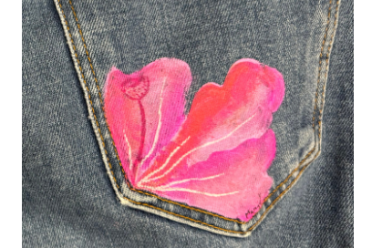 gros plan sur une pche arrière de jeans gris, rehaussée d'une fleur aux tons dégradés de rose avec effet de mouvement et pistil dessinés à la peinture en surimpression - Agrandir l'image, fenêtre modale