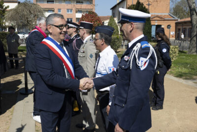 le Maire serre la main à un policier en uniforme, dans un parc - Agrandir l'image 14 sur 16, fenêtre modale