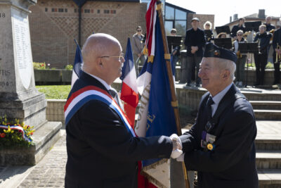 photo d'un homme qui porte une écharpe en train de serrer la main à un porteur de drapeau - Agrandir l'image 15 sur 16, fenêtre modale
