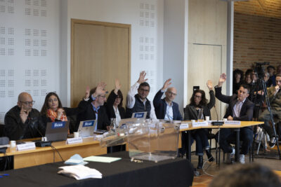 photo de personnes derrière la table du conseil qui lèvent la main pour voter - Agrandir l'image 16 sur 16, fenêtre modale