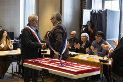 photo du Maire qui serre la main à un élu qui porte l'écharpe - Agrandir l'image 8 sur 16, fenêtre modale