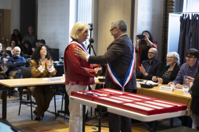 photo du Maire qui porte l'écharpe et serre la main à une élue qui la porte également - Agrandir l'image 13 sur 16, fenêtre modale