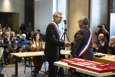 photo du Maire qui serre la main à un élu qui porte l'écharpe - Agrandir l'image 14 sur 16, fenêtre modale