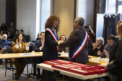 photo du Maire qui serre la main d'une élue qui porte l'écharpe - Agrandir l'image 15 sur 16, fenêtre modale