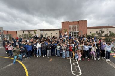 photo de groupe des écoliers de Petit Train dans la cour de l'école, habillés en bleu
