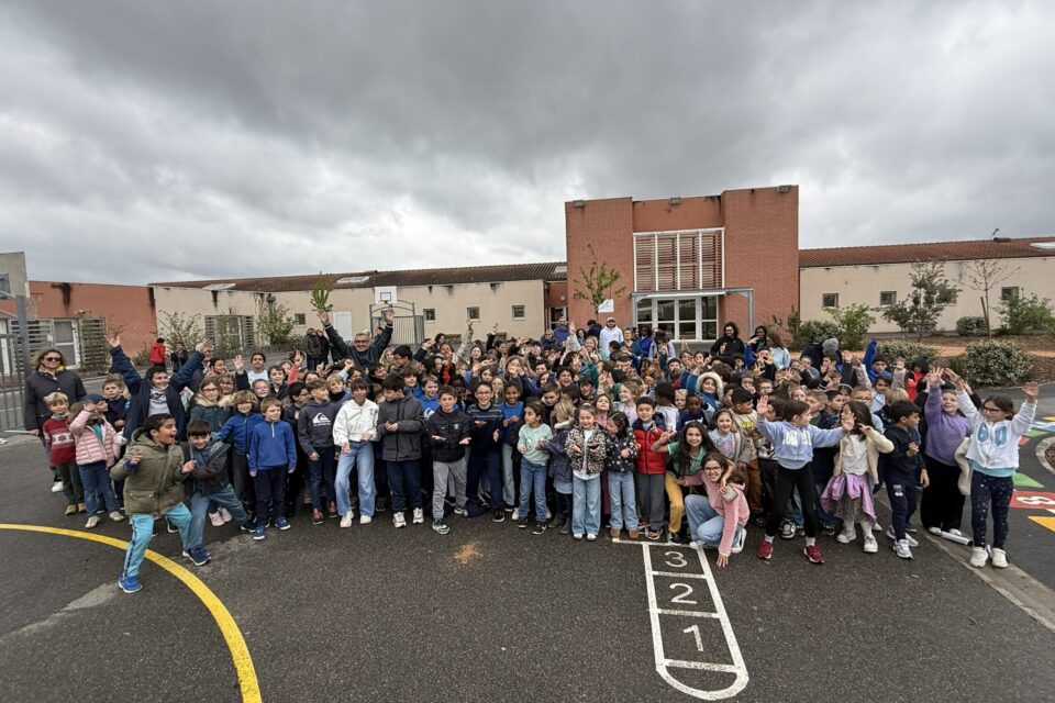 photo de groupe des écoliers de Petit Train dans la cour de l'école, habillés en bleu