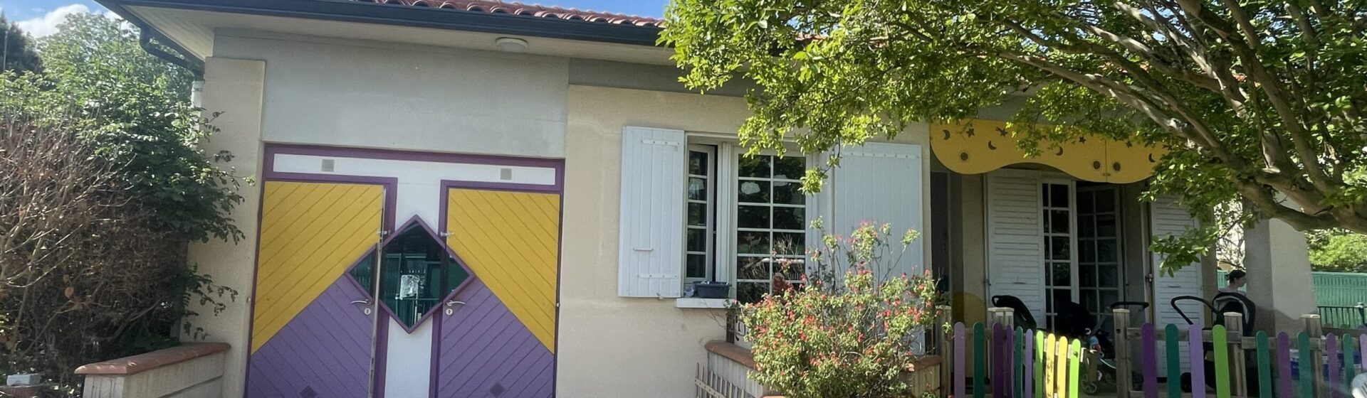 Photo de la façade d'une maison avec des portes colorées, sous un ciel bleu
