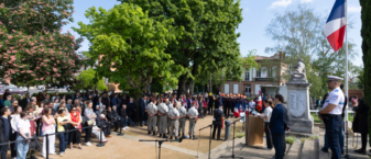 Photo d'une commémoration devant le monument aux morts, on aperçoit le public sur la gauche et les militaires et officiels au centre de la photo
