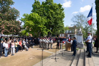 Photo d'une commémoration devant le monument aux morts, on aperçoit le public sur la gauche et les militaires et officiels au centre de la photo - Agrandir l'image, fenêtre modale