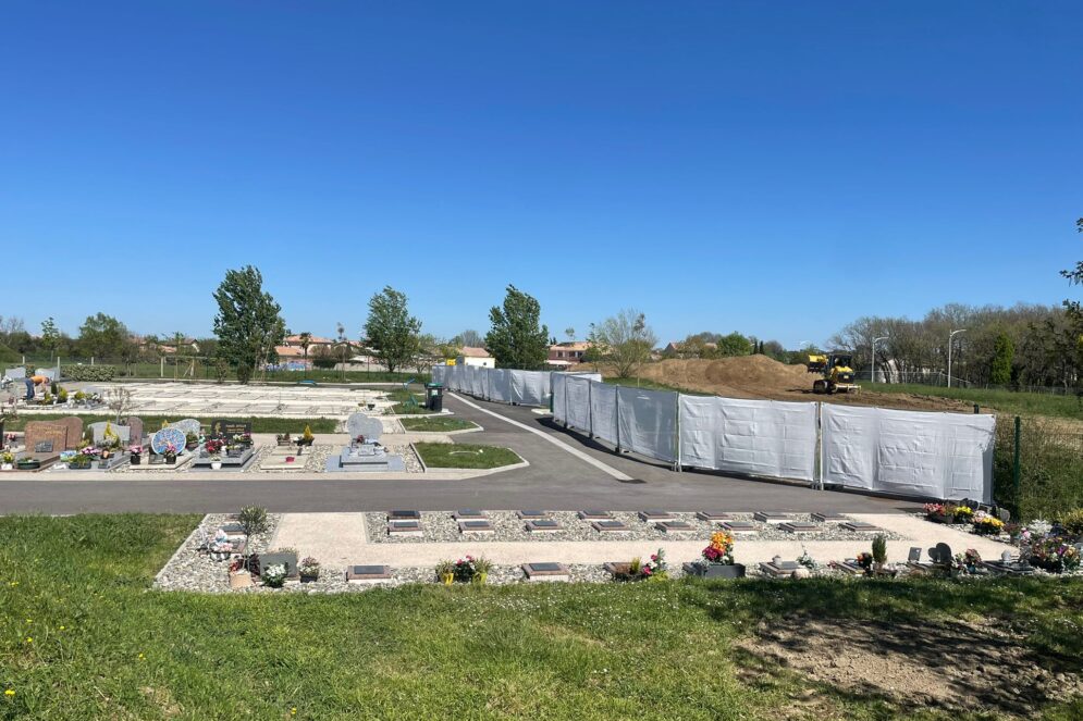 photo d'un cimetière en travaux, sous un grand ciel bleu. On voit sur la partie droite de la photo la zone en travaux
