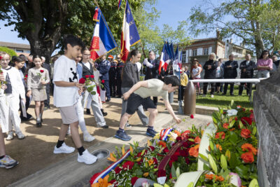 photo de jeunes qui déposent des roses à côté des gerbes de fleurs devant le monument aux morts - Agrandir l'image 19 sur 26, fenêtre modale