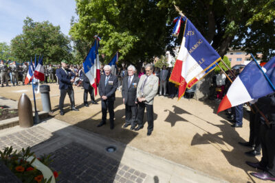 photo de trois hommes âgés au centre, dans un square ensoleillé, avec les porteurs de drapeau de chaque côté - Agrandir l'image 26 sur 26, fenêtre modale