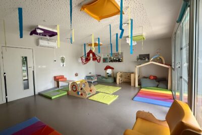 photo d'une pièce grande avec tatamis au sol, structures de jeux et de repos, bandes de papier suspendues au plafond - Agrandir l'image 3 sur 8, fenêtre modale