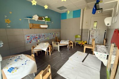 photo d'une pièce d'atelier créatif avec table et papiers blancs, des gommettes, au plafond des étoiles suspendues en papier - Agrandir l'image 6 sur 8, fenêtre modale