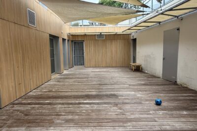 photo d'une terrasse de crèche en bois, avec ballon plastique bleu, et toiles d'ombrage - Agrandir l'image 8 sur 8, fenêtre modale