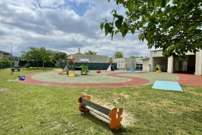 photo de l'extérieur de la crèche avec jardin, jeux pour enfants, sous un ciel bleu et nuages - Agrandir l'image 2 sur 10, fenêtre modale
