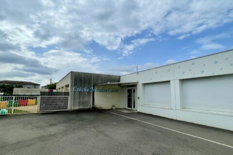 photo de façade d'entrée de la crèche Moulin Câlin sous un ciel bleu et nuages blancs