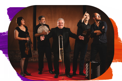 Portrait d'un ensemble de musique composé de cinq personnes habillées en noir, debout sur un tapis rouge devant un fond en bois sombre : Au centre : Un homme souriant, les bras ouverts, présente une sacqueboute (trombone ancien) posée verticalement devant lui. À gauche : Une femme tenant un violon et un homme tenant une percussion (tambour de basque). À droite : Un homme pointant le doigt vers le haut à côté d'un autre homme aux bras croisés. Un accordéon est posé au sol à leurs pieds. - Agrandir l'image, fenêtre modale