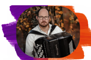 L'accordéoniste Grégory Daltin, en bras de chemise blanche , lunettes rondes, moustache et collier de barbe, pose face caméra avec son instrument, la végétation d'un parc en automne apparaissant dans son dos.