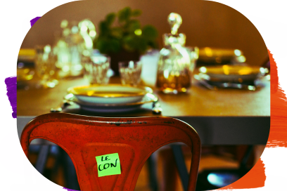 Gros plan sur le dossier d'une chaise rouge avec un post-it vert indiquant « LE CON », devant une table de salle à manger dressée et floue en arrière-plan. - Agrandir l'image, fenêtre modale