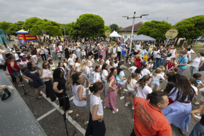 photo du monde rassemblé en extérieur, des jeunes filles en teeshirt blanc dansent devant le public - Agrandir l'image 7 sur 14, fenêtre modale