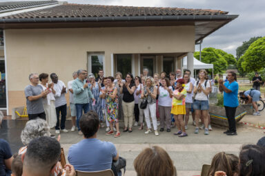 photo d'une trentaine de personnes rassemblées devant la maison de quartier, qui applaudissent ensemble