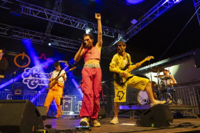 photo d'un groupe de musque rock en plein concert, quatre hommes sur scène, deux guitares, un chanteur et un batteur, de nuit, le chanteur lève le poing - Agrandir l'image 14 sur 14, fenêtre modale
