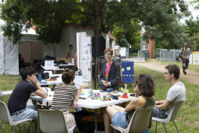 photo de plusieurs personnes dans un parc assis autour d'une table, qui échangent avec une élue - Agrandir l'image 2 sur 19, fenêtre modale