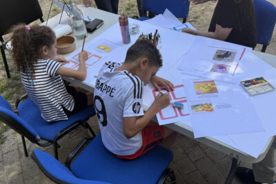 photo de deux enfants en train de dessiner sur une table en extérieur - Agrandir l'image 17 sur 19, fenêtre modale