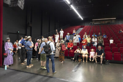 photo d'une trentaine de personnes réunies dans une salle de spectacles, assises sur les sièges rouges - Agrandir l'image 9 sur 13, fenêtre modale