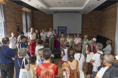 photo d'une cinquantaine de personnes rassemblées dans une grande belle salle aux murs de brique rouge, vus de dos ils font face au Maire au micro et aux élus à ses côtés - Agrandir l'image 10 sur 13, fenêtre modale