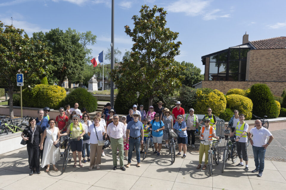 Photo de l'ensemble des participants sur le parvis de la Mairie, des familles et élus, certains avec vélo