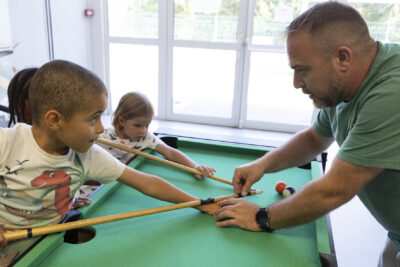 photo de deux enfants qui jouent au billard avec un animateur dans une salle - Agrandir l'image 6 sur 21, fenêtre modale