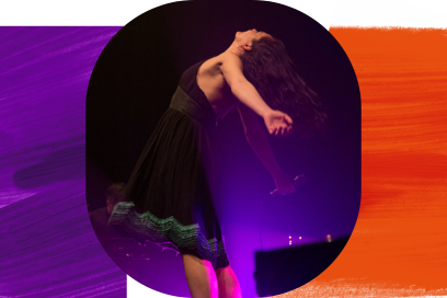 La comédienne debout pieds nus en robe de satin noire et taffetas rehaussé de broderies vert se tien debout de profil dans la lumière violette de scène l'ombre d'un piano visible en arrière-plan. - Agrandir l'image, fenêtre modale
