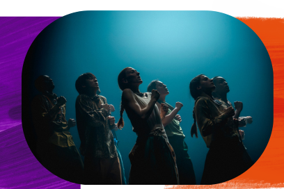 Dans une lumière bleue qui évoque le fonds marin, les danseurs et danseuses apparaissent en rgangs debout les corps légèrement ombrés, bras et mains repliés sur leur torse, visages jetés en arrière dans un mouvement synchronisé, se dirigeant en ballet vers la droite de l'image. - Agrandir l'image, fenêtre modale