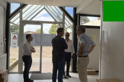 photo d'une entrée d'école avec quatre personnes debout, sol neuf, faux plafonds neufs - Agrandir l'image 1 sur 2, fenêtre modale