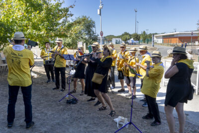 photo d'une bandas en train de jouer, on voit une quinzaine de musiciens, habillés en jaune - Agrandir l'image 9 sur 14, fenêtre modale