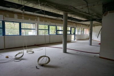 photo d'un espace intérieur en travaux, vide, avec des cables et surfaces en béton, sur la gauche des fenêtres en ligne - Agrandir l'image 1 sur 3, fenêtre modale