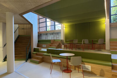 photo paysage d'un espace de travail, avec gradins, tables et espace tablette face aux grandes fenêtres, déco bois et peinture vert clair - Agrandir l'image 2 sur 2, fenêtre modale