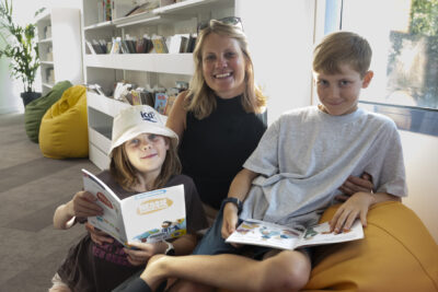 photo d'une femme et deux enfants assis sur un gros pouf en train de lire et sourire à l'objectif - Agrandir l'image 18 sur 19, fenêtre modale
